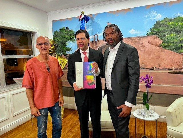 Artista dominicano Van Robert entrega a Roberto Ángel Salcedo libro de colección internacional